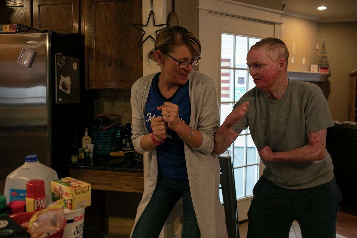 Zachary Sutterfield wrestles with his mom, Deona Jo “DJ” Sutterfield, as they make dinner at their San Angelo home. The family was able to celebrate Christmas at home for the first time since Zach suffered critical injuries in a deadly San Marcos apartment fire 18 months ago.