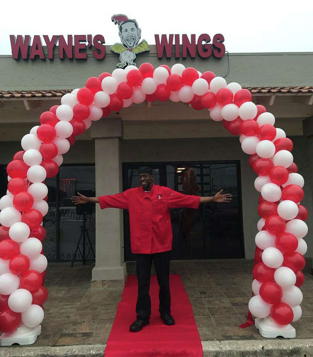 Wayne’s Wings owner Dwayne Price celebrates the grand opening of his new