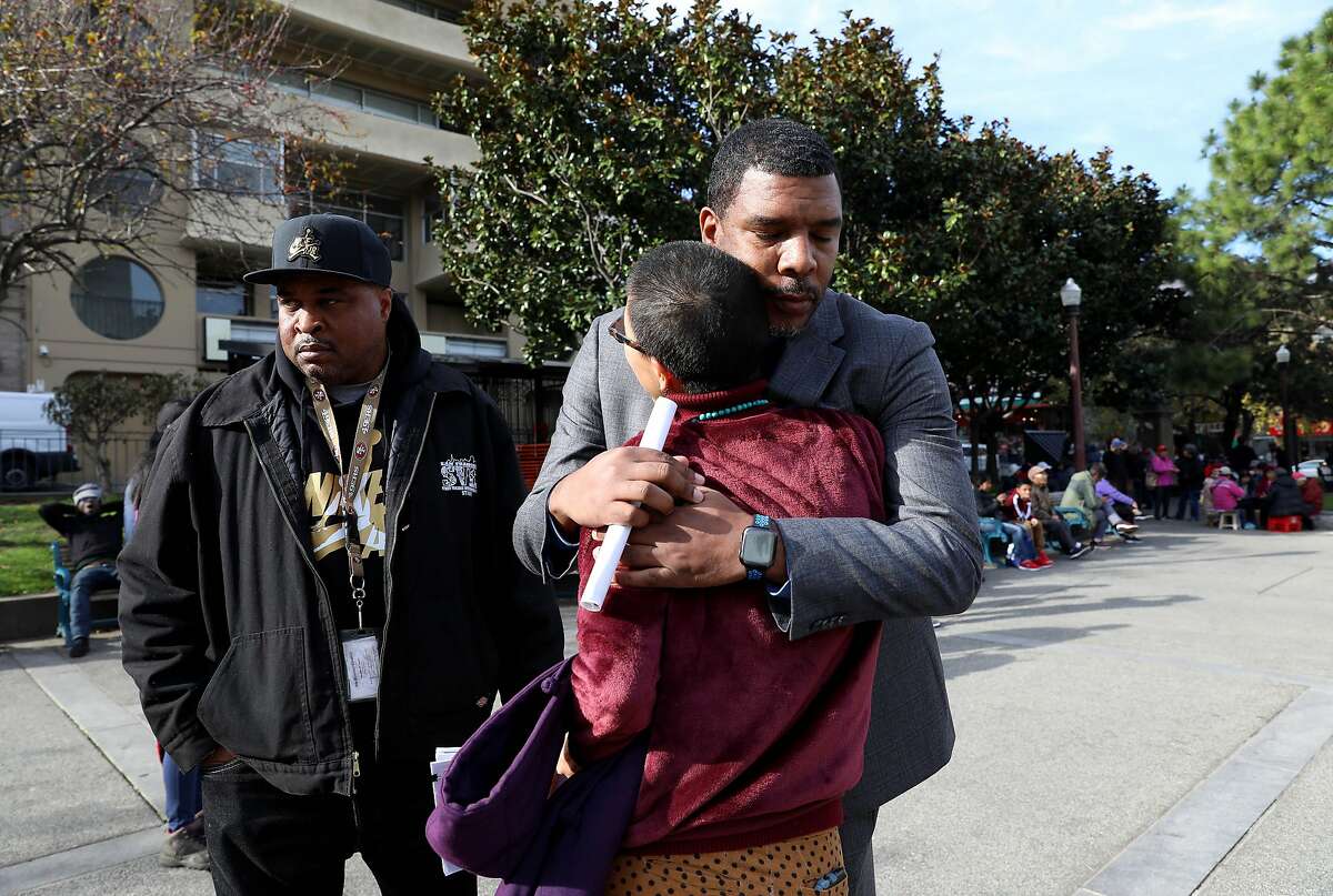 James Caldwell, right, Crisis Response Manager, Street Violence Intervention Program (SVIP), hugs Sasanna Yee, a community healer and organizer, as Victor Jones, a staff member at SVIP (left), stands nearby while the group meets at Chinatown's Pourtsmouth Square in San Francisco, Calif., on Tuesday, December 31, 2019. SVIP has helped intervene in neighborhood trouble driving down violence and homicides in San Francisco to an all time low in 2019. It's been patrolling Chinatown, where in recent weeks there have been a number of high-profile, high-violence incidents, including one in which an elderly man was beaten by a group of four to six much younger men, apparently unprovoked. The SVIP team has been working Chinatown to increase it's presence there in an effort to prevent any further violence.