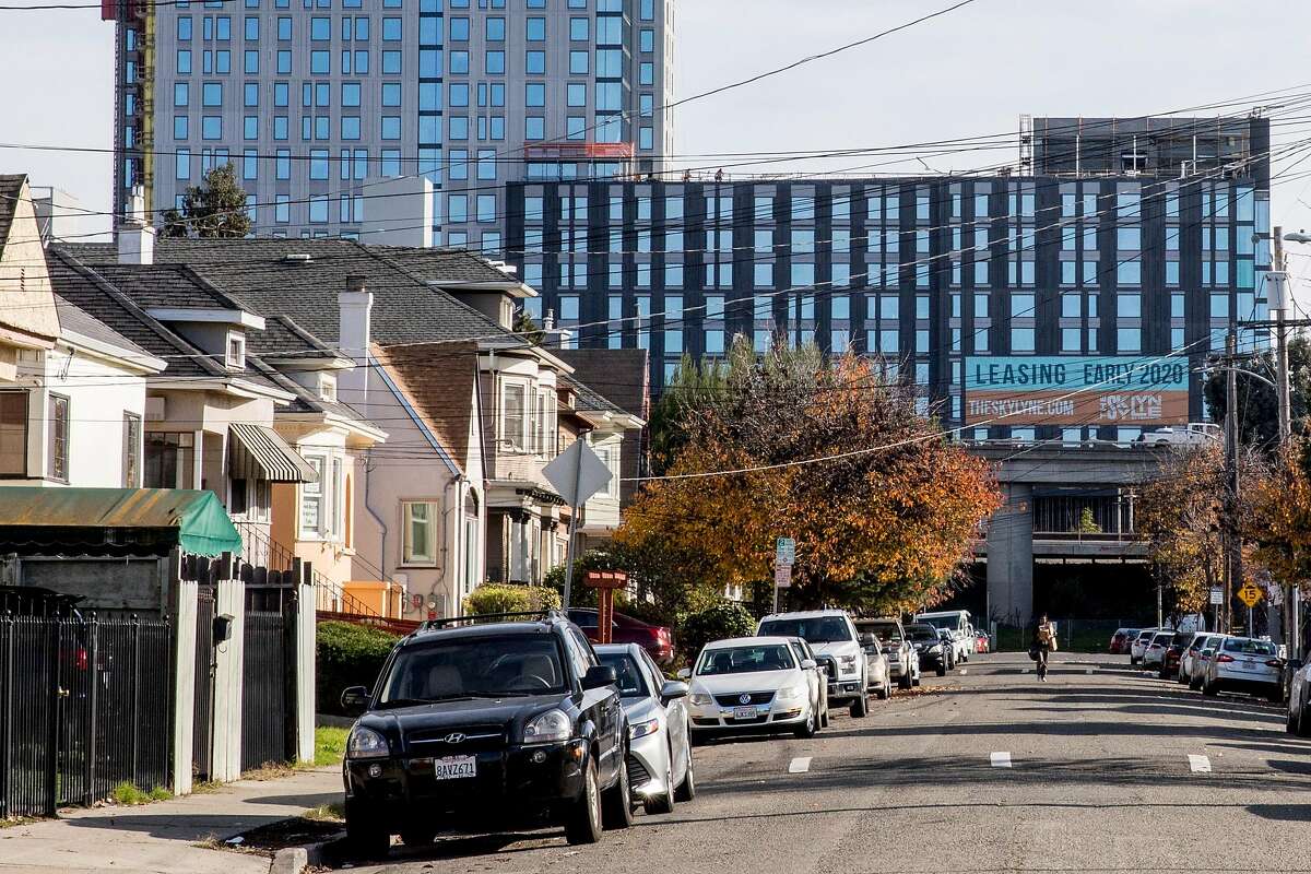 Traditional homes are seen against a new housing development in a neighborhood along West Street in Oakland, Calif. Thursday, January 2, 2020 in the same neighborhood where a warehouse fire broke out in the early morning hours of Friday, Dec. 27, 2019.