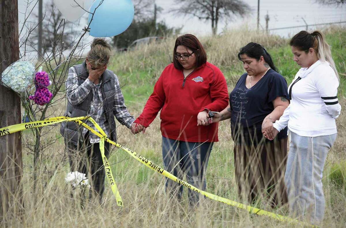 Mourners Sylvia Santana, left to right, Diamond Moreno, Margarita Santoya and Mary De La Rosa pray after placing flowers, balloons and stuffed toys on Jan. 11, 2019, near the site where authorities found the body of 8-month-old King Jay Davila wrapped in a blanket and buried in a backpack next to Rosillo Creek by Rittiman Road.