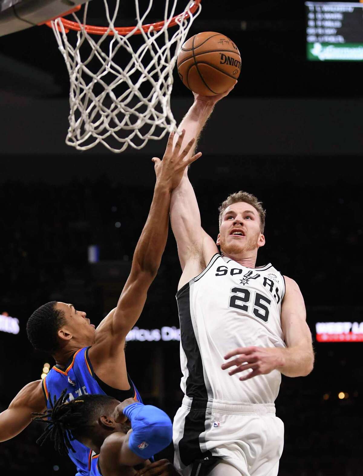 Jakob Poeltl of the San Antonio Spurs (25) dunks the ball over Darius Bazley (7) and Nerlens Noel (9) of the Oklahoma City Thunder during NBA action in the AT&T Center on Thursday, Jan. 2, 2020.