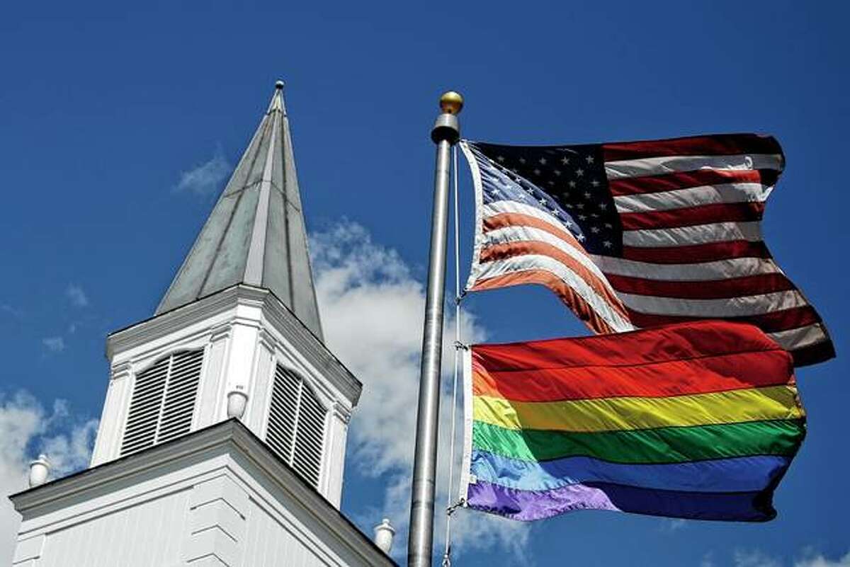 A gay pride rainbow flag flies along with the U.S. flag in April in front of Asbury United Methodist Church in Prairie Village, Kansas. United Methodist Church leaders are proposing a separation that would let more traditional denominations break away because of a disagreement over the UMC’s official stance on gay marriage.