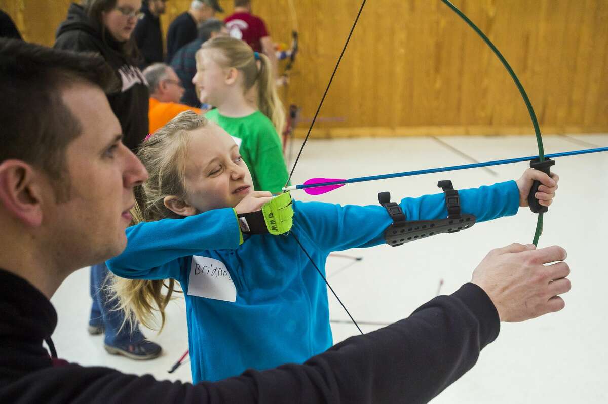 Brianna Mathews of Midland, 8, prepares to release an arrow during an archery camp for local girl scouts Saturday, Jan. 4, 2020 at Mid-Michee Bowmen in Midland. (Katy Kildee/kkildee@mdn.net)