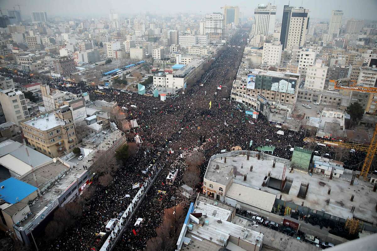 Iranians march behind a vehicle carrying the coffins of slain major general Qassem Soleimani and others as they pay homage in the northeastern city of Mashhad on January 5, 2020. - Iran has cancelled a Tehran ceremony to honour slain general Qasem Soleimani due to an overwhelming turnout by mourners in second city Mashhad, the Revolutionary Guards said. (Photo by MOHAMMAD TAGHI / TASNIM NEWS / AFP) (Photo by MOHAMMAD TAGHI/TASNIM NEWS/AFP via Getty Images)