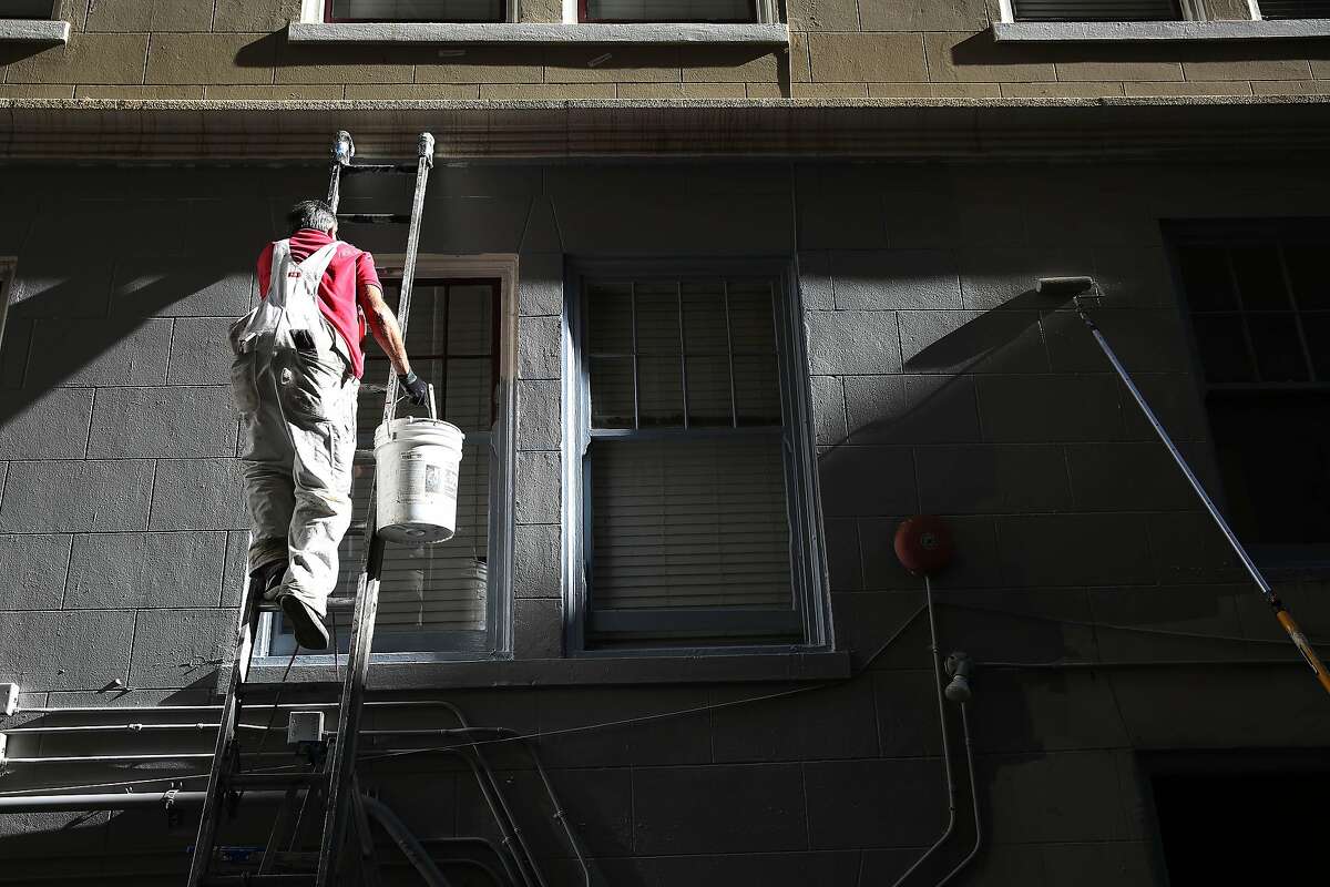 Jorge Gomez, painter Bay Area Painting, climbs a ladder while painting the exterior of the Abigail Hotel on Monday, January 6, 2020 in San Francisco, Calif.