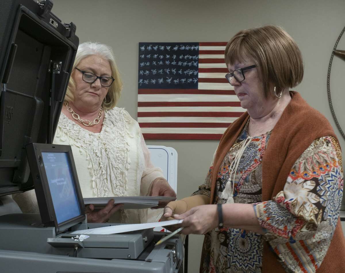 Carolyn Grays, right, feeds one ballot at a time as she and Beth Shock test the DS200 01/07/20 during testing of ballot machines at the Midland County Elections office. Tim Fischer/Reporter-Telegram