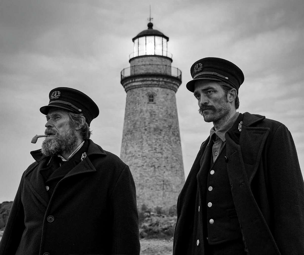 Willem Dafoe (left) and Robert Pattinson are too close for comfort in “The Lighthouse.”