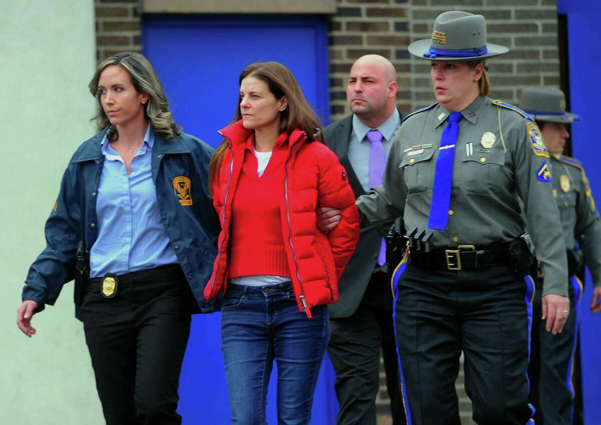 Michelle Troconis is escorted to an awating police vehicle after being arrested and processed at State Police Troop G Headquarters in Bridgeport, Conn., on Tuesday Jan. 7, 2020.