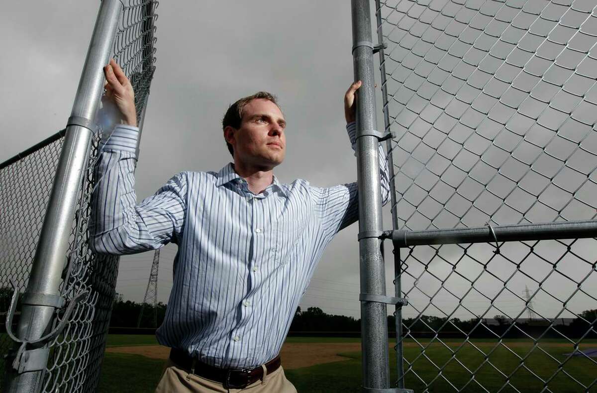FILE - In this May 23, 2013, photo, Garrett Broshuis poses for a photo at a baseball field in St. Louis. Broshuis is the driving force of a lawsuit against Major League Baseball, alleging violations of federal wage and overtime laws in a case some legal observers suggest has significant merit. (AP Photo/Jeff Roberson, File)