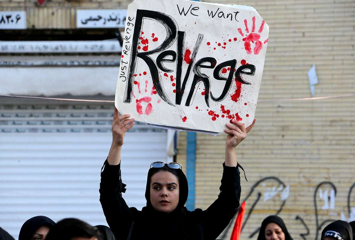 An Iranian mourner holds a placard during the final stage of funeral processions for slain top general Qasem Soleimani, in his hometown Kerman on January 7, 2020. As tensions over the U.S. assassination have eased, oil prices have dropped.