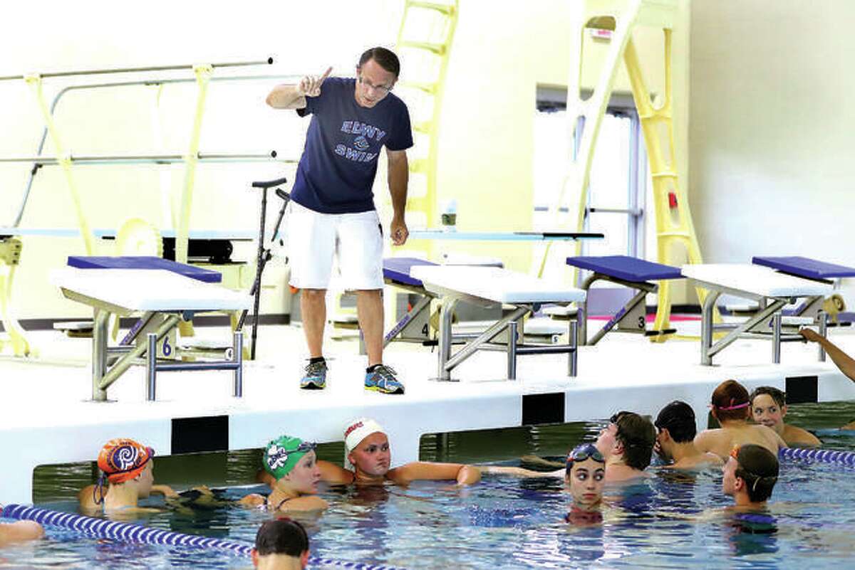 Edwardsville YMCA Breakers swim team coach Bob Rettle addresses some of his swimmers at a practice session in the Chuck fruit Aquatic Center at Edwardsville High School.
