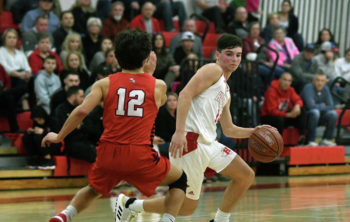 Huffman Hargrave's Cody Oiliphant, right, works the ball in the front court against a Huntington defender in the fourth quarter of their district matchup at Hargrave High School on Jan. 7, 2020.