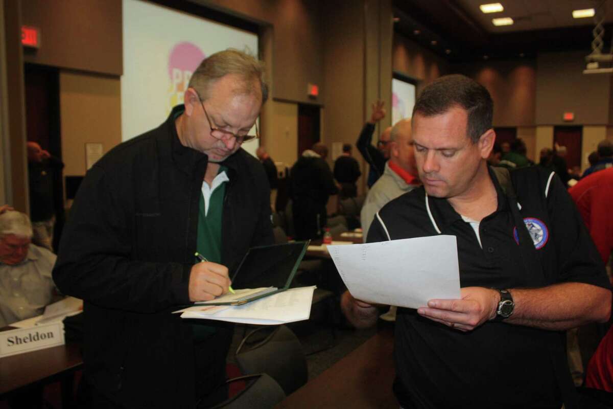 Former Pasadena ISD Athletic Director Rodney Chant (right) and former Pasadena head football coach Jeff Ganske look over a UIL's past realignment announcement. The Pasadena ISD schools are 26 days away from learning their newest biennial realignment fate.