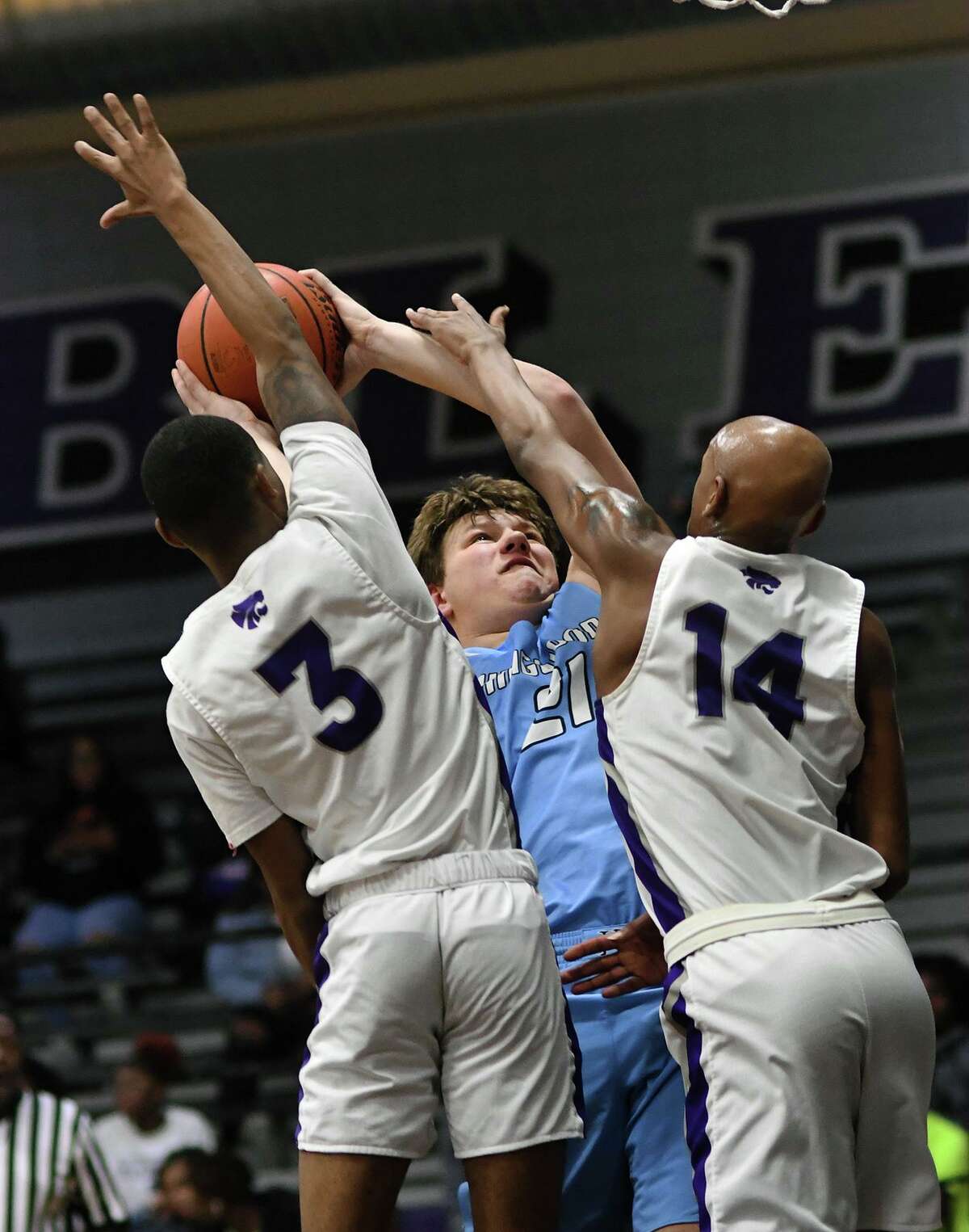 Kingwood senior Nick Neuman (21) gets a double dose of defense from Humble seniors Treymayne Toliver (3) and Tristen Charles (14) on a play late in the second quarter of their District 22-6A matchup at Humble High School on Jan. 7, 2020.