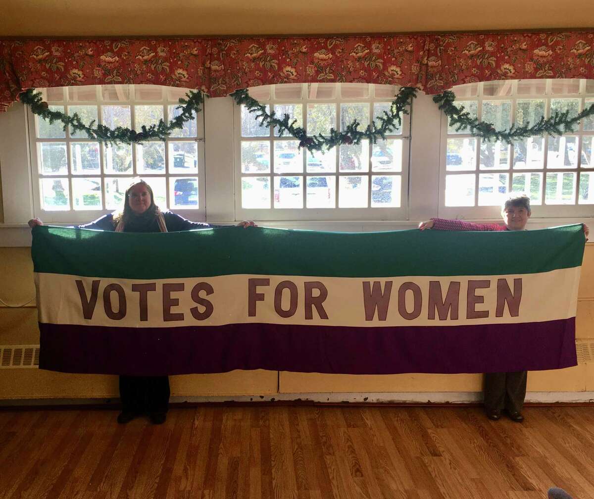 Marilyn Carroll, president of League of Women Voters of Ridgefield, left, and Rev. Maria Pia Seirup, right, hold up the replica of the League's 11'x 3' 1911 Votes for Women Banner which Rev. Seirup created. It will be