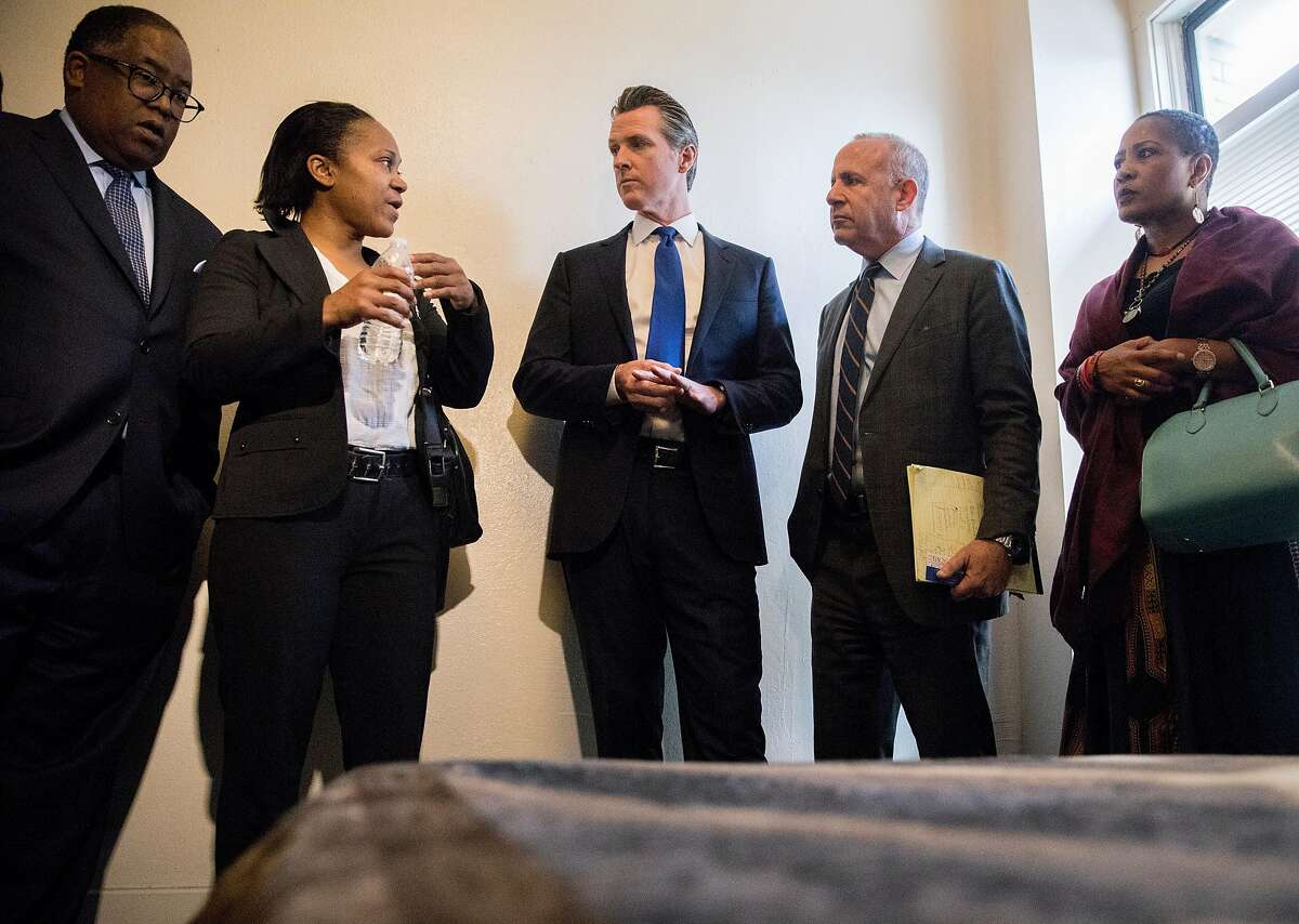 In this file photo from May 2019, (From left) Los Angeles County Supervisor Mark Ridley-Thomas, former resident Tekel Carlisle, 42, California Governor Gavin Newsom, Sacramento Mayor Darrell Steinberg and Oakland City Councilmember Lynette Gibson McElhaney are touring rooms at the the Henry Robinson Multi-Service Center in Oakland, CA before a press conference announcing a newly created state-level homeless commission.Newsom signed an executive order on Wednesday to have state agencies use vacant land for homeless housing and shelter.
