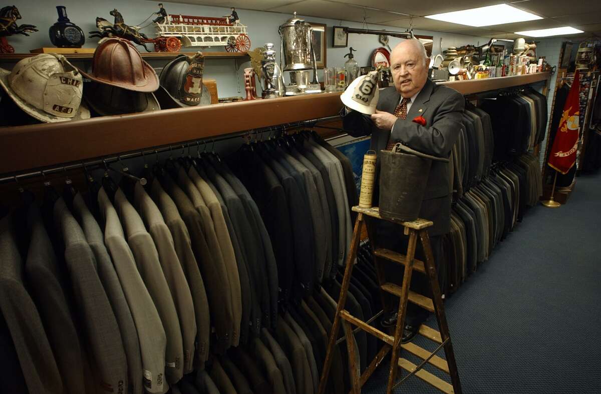 Ansonia, Connecticut-2/20/03: Recipient of the Dr. John I. Howe Award by the Derby Historical Society,Charles Seccombe, owner of Seccombe's Men's Shop, is the "caretaker" of historical and antique items that was either given to him by donors or personal collection in his clothing store. The award honors his attempts at preserving local history. Heholds the circa1877 Ansonia Fire Dept. helmet that belonged to second assistant fire chief Arthur Bartholomew who was also the first mayor of Ansonia, a leather fire brigade bucket and an antique fire extinquisher. ©2003 Peter Hvizdak ph0082c #2103