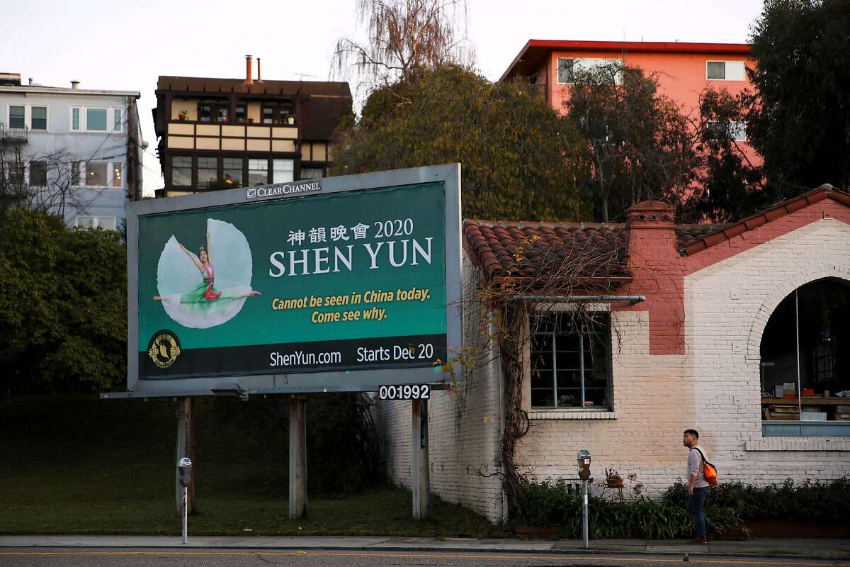 A man walks near a Shen Yun billboard as he approaches Park Blvd. and East 20th Street, in Oakland, Calif., on Tuesday, January 7, 2020.