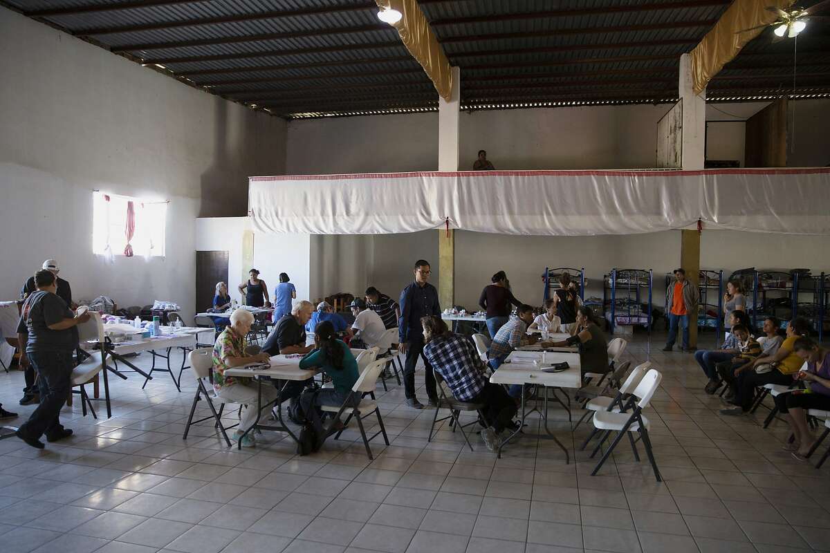 In this Oct. 26, 2019, photo, volunteer health practitioners set up a clinic in a shelter for migrants in Tijuana, Mexico. The health crisis spans both sides of the border. In the past year, at least three children, detained by U.S. Border Patrol agents, have died from the flu while being held. They include a 16-year-old boy who was seen on security footage writhing in agony on the floor in a U.S. Border Patrol holding cell.