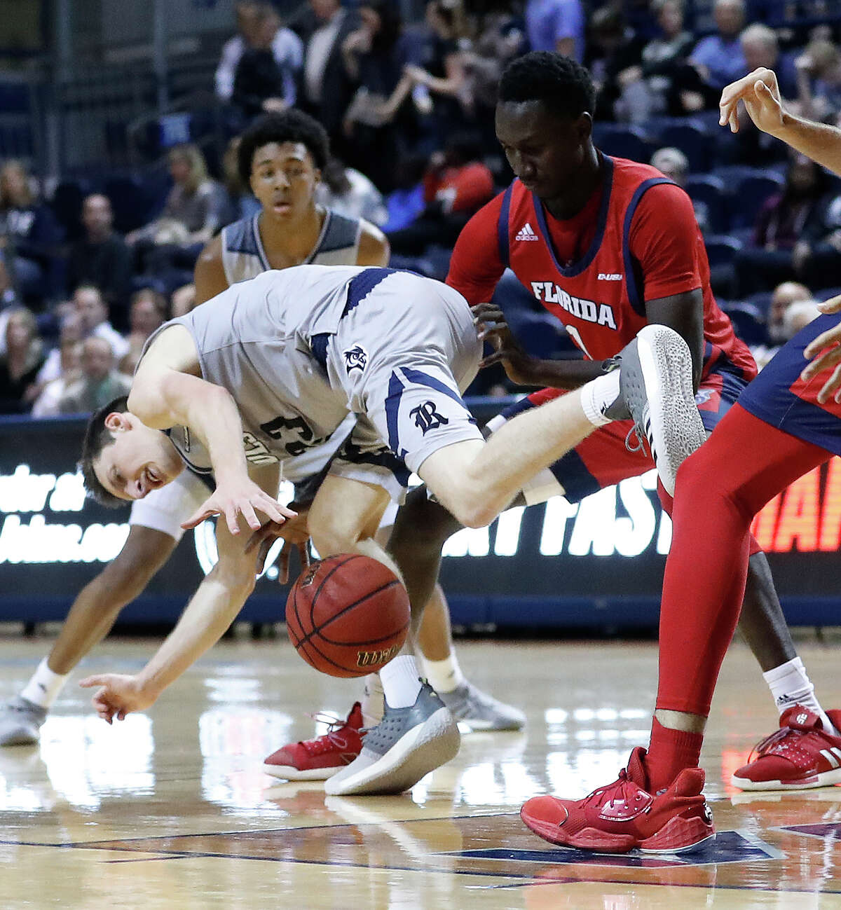 Rice Owls guard Drew Peterson (23) stumbles as he tries to stay in control of the ball against Florida Atlantic Owls forward Madiaw Niang (1) during the first half of an NCAA men's college basketball game at Tudor Fieldhouse Thursday, Jan. 9, 2020, in Houston.