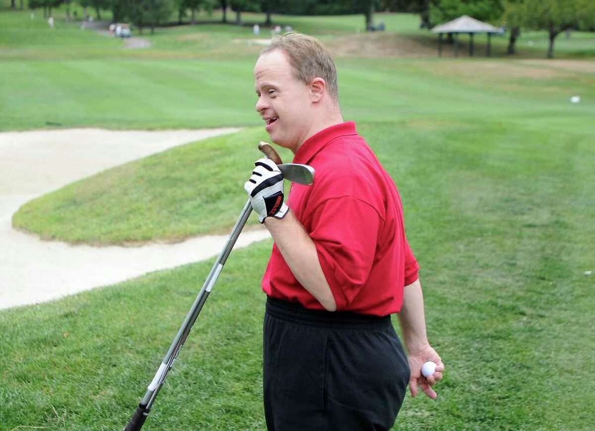 Christopher Backiel walks back to his cart during the Challenged People In Motion golf tournament at Sterling Farms Golf Course in Stamford, Conn. on Thursday August 12, 2010.
