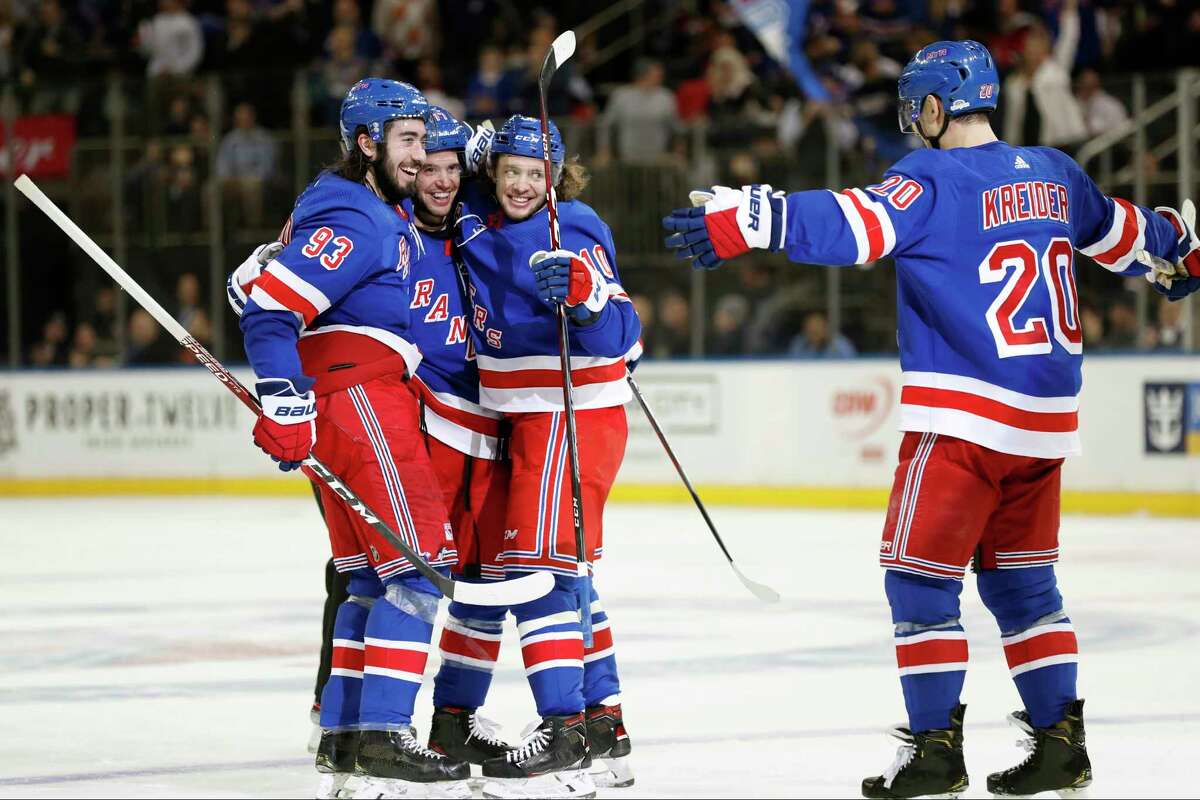 New York Rangers center Mika Zibanejad (93), defenseman Tony DeAngelo (77) and and left wing Artemi Panarin (10) embrace while celebrating DeAngelo's third goal as Rangers left wing Chris Kreider (20) approaches the group during the second period of an NHL hockey game against the New Jersey Devils, Thursday, Jan. 9, 2020, in New York. (AP Photo/Kathy Willens)
