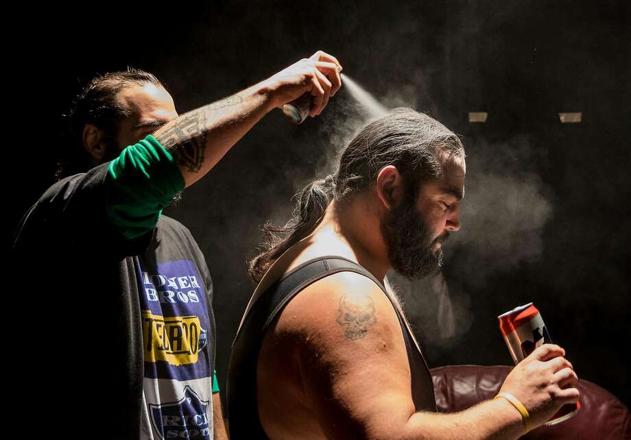 The Stoner Brothers help each other get ready for their wrestling match before the start of an 80's-themed Hoodslam event at Oakland Metro Operahouse in Oakland, Calif. Friday, Nov. 29, 2019. Photo: Jessica Christian / The Chronicle 2019