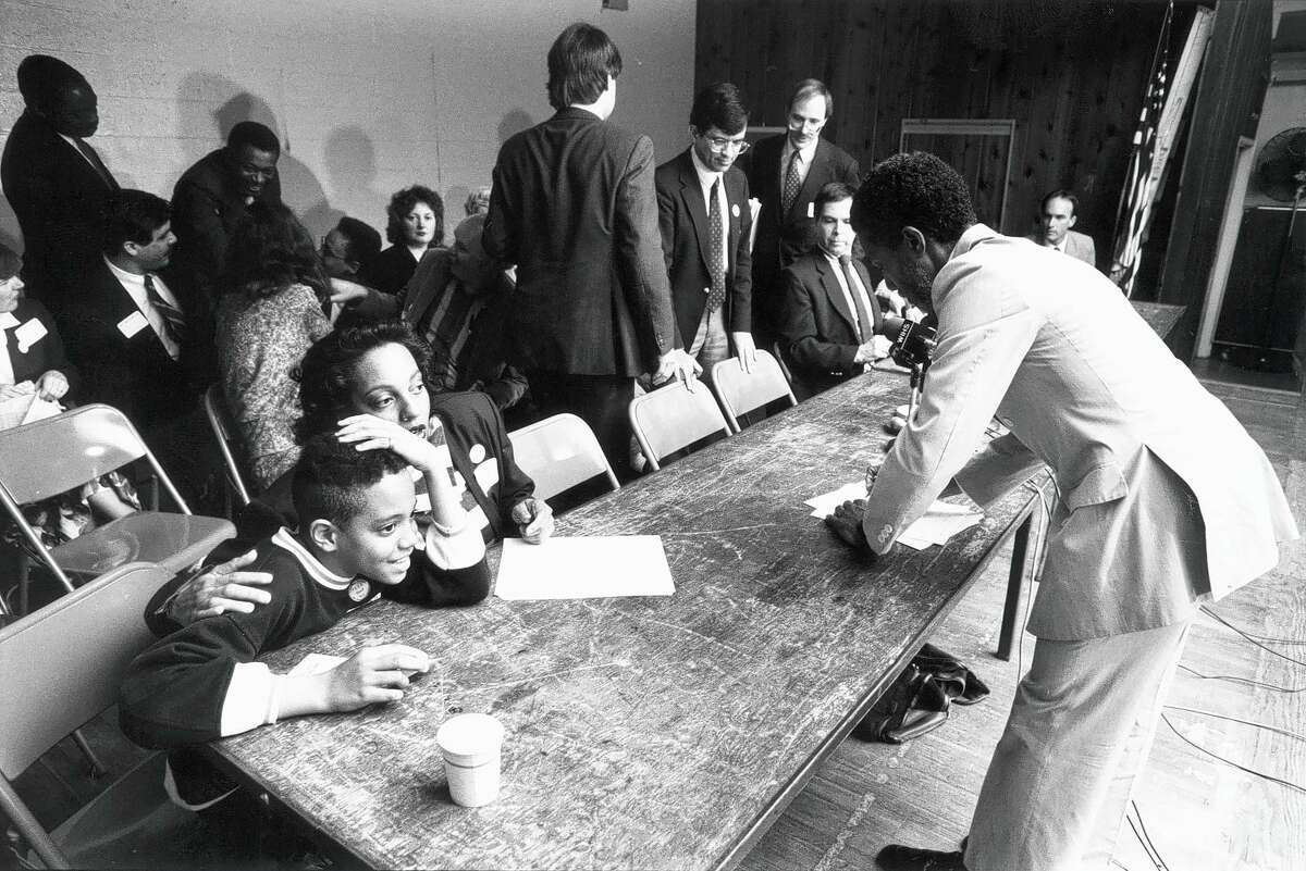 Elizabeth Sheff tries to ally the anxiety felt by her son Milo, 10, before the start of a press conference on April 27, 1989, announcing a desegregation lawsuit against the state. At right is UConn law professor John C. Brittain, one of several lawyers who argued their case.
