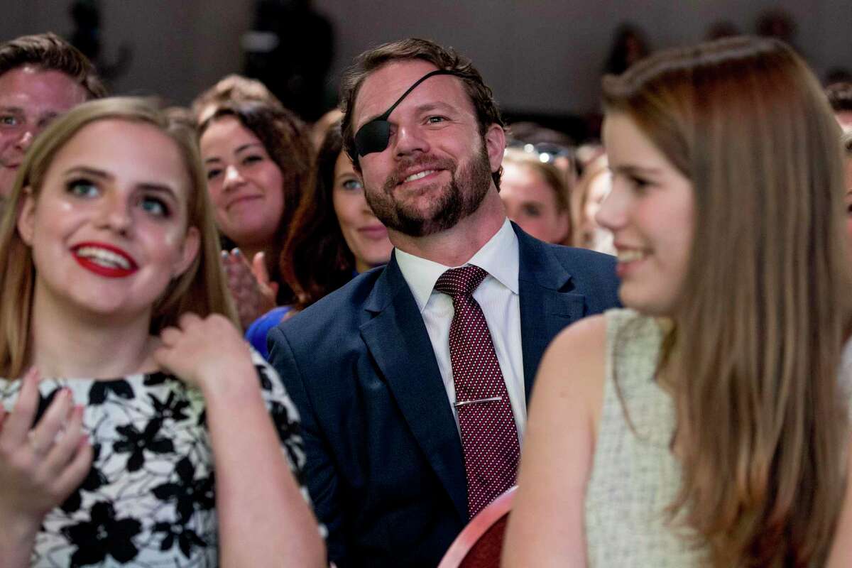 Rep. Dan Crenshaw, R-Texas, center, smiles as President Donald Trump calls out to him as he speaks at the Turning Point USA Student Action Summit at the Palm Beach County Convention Center in West Palm Beach, Fla., Saturday, Dec. 21, 2019.
