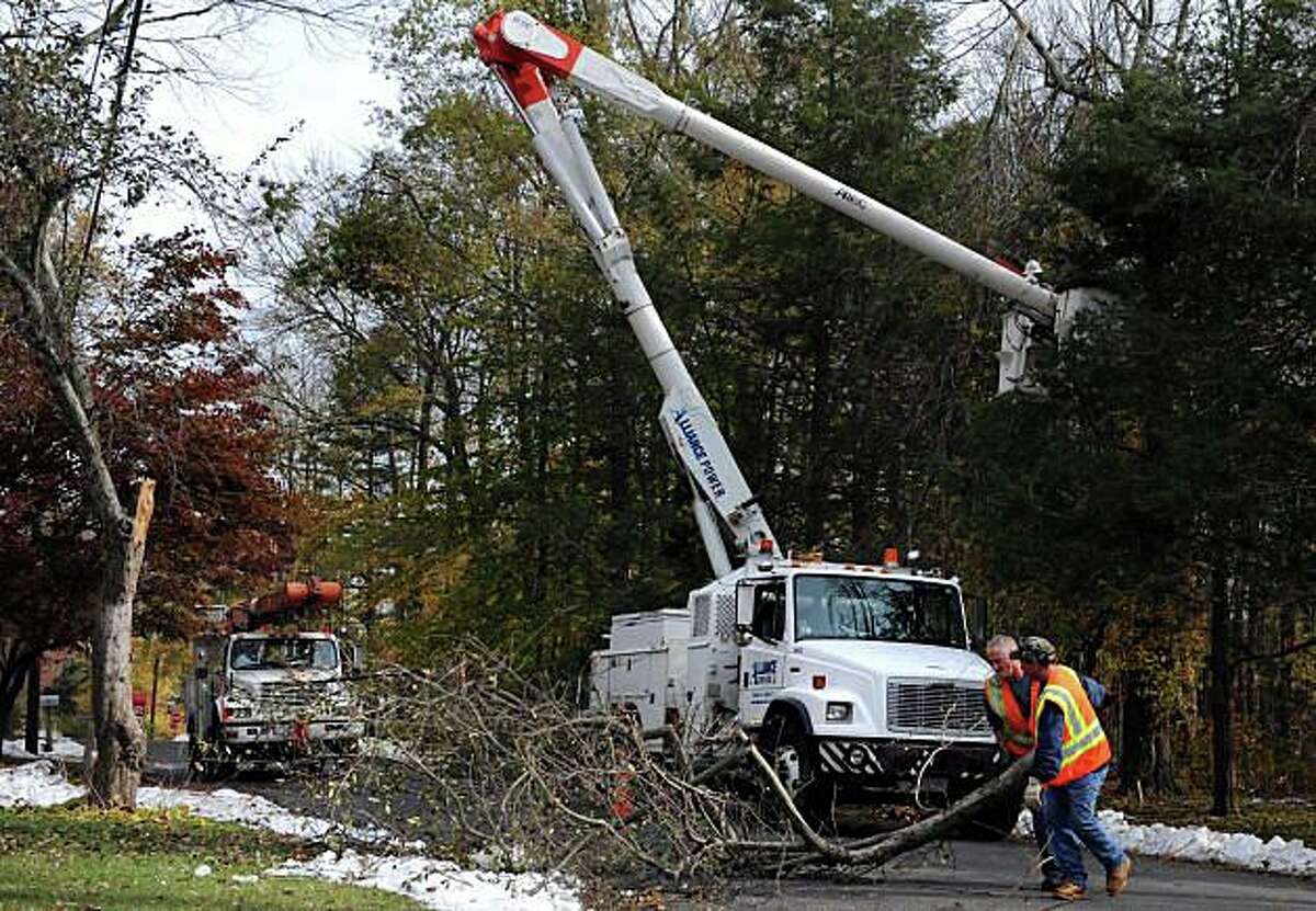United Illuminating Co. crews work on trees in the wake of power outages caused by trees felled in storms.