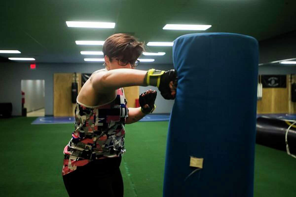 Adrienne Gibson of Hope hits a punching bag during a kickboxing class Thursday at Edge Fitness and Training Headquarters in Midland. (Katy Kildee/kkildee@mdn.net)