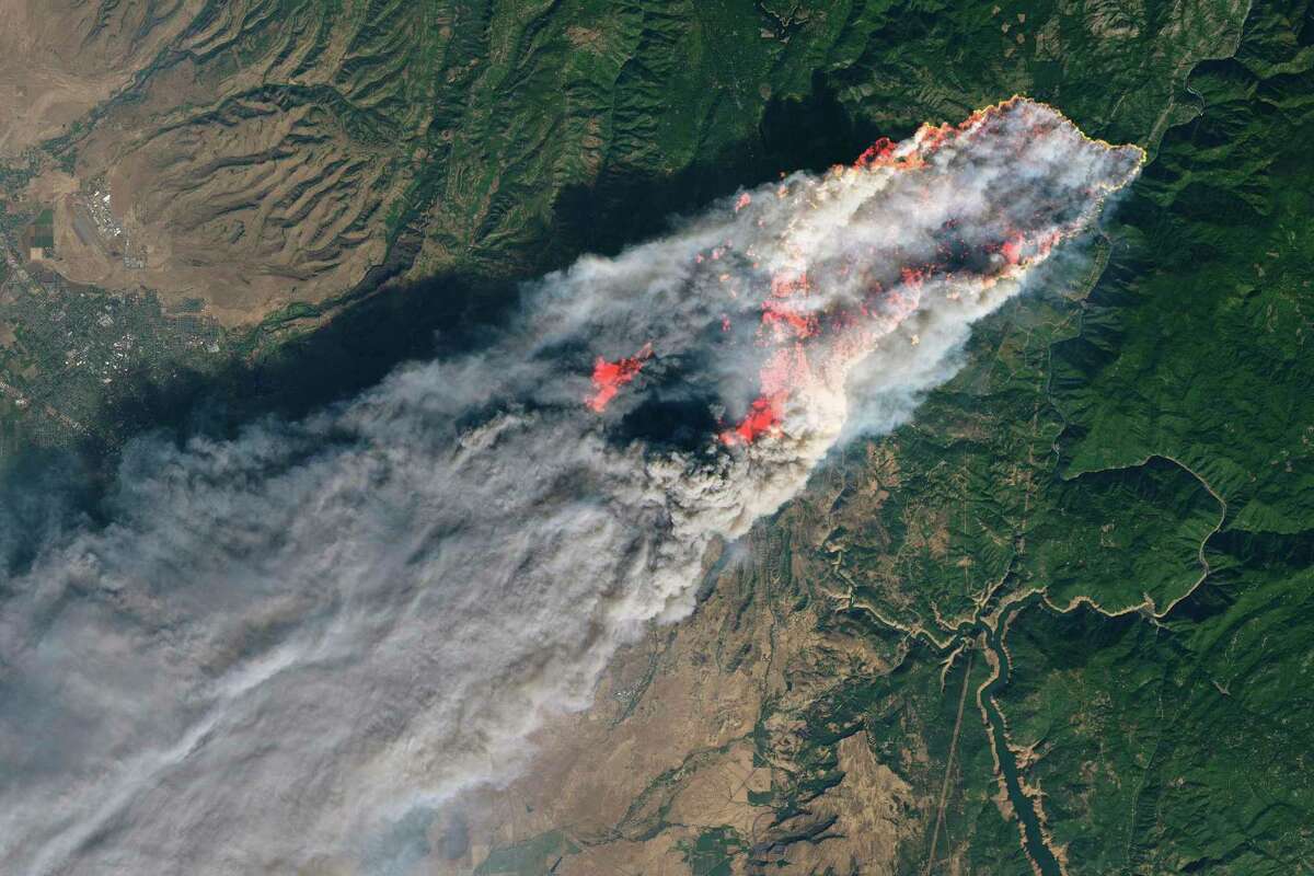 This November 2018 image provided by NASA shows flames and smoke from the Camp Fire that erupted 90 miles (140 kilometers) north of Sacramento, Calif. Increasingly intense wildfires that have scorched forests from California to Australia are stoking worry about long-term health impacts from smoke exposure in affected cities and towns. (NASA via AP)
