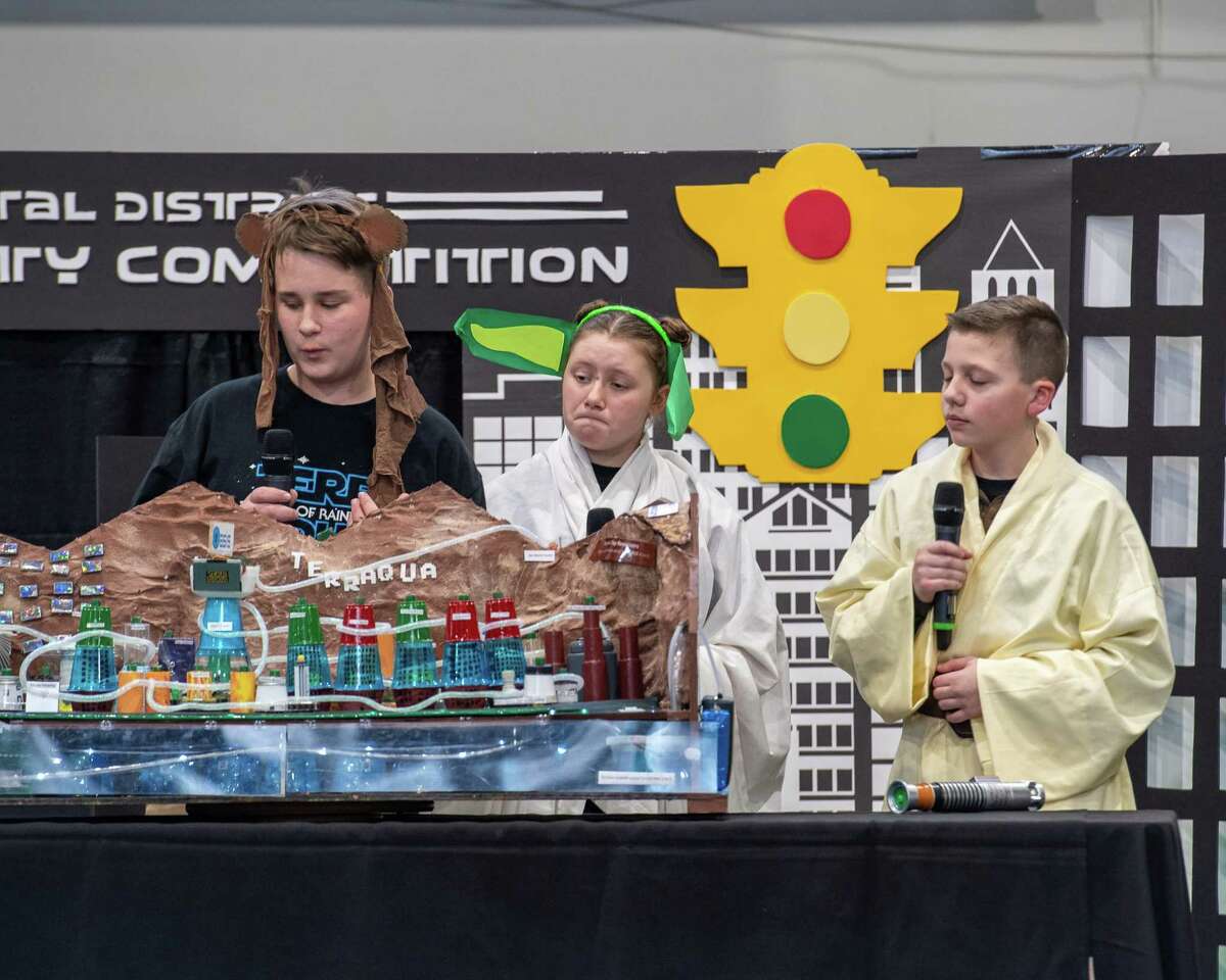 Broadalbin Middle School students Trenton Richmond, Emma Watermann and Owen Compani, dressed as the Star Wars characters, present the city of Terraqua to a panel of judges during the annual National Engineers Week Future City Competition held at the Sage College Armory on Saturday, Jan. 11, 2019 (Jim Franco/Special to the Times Union.)