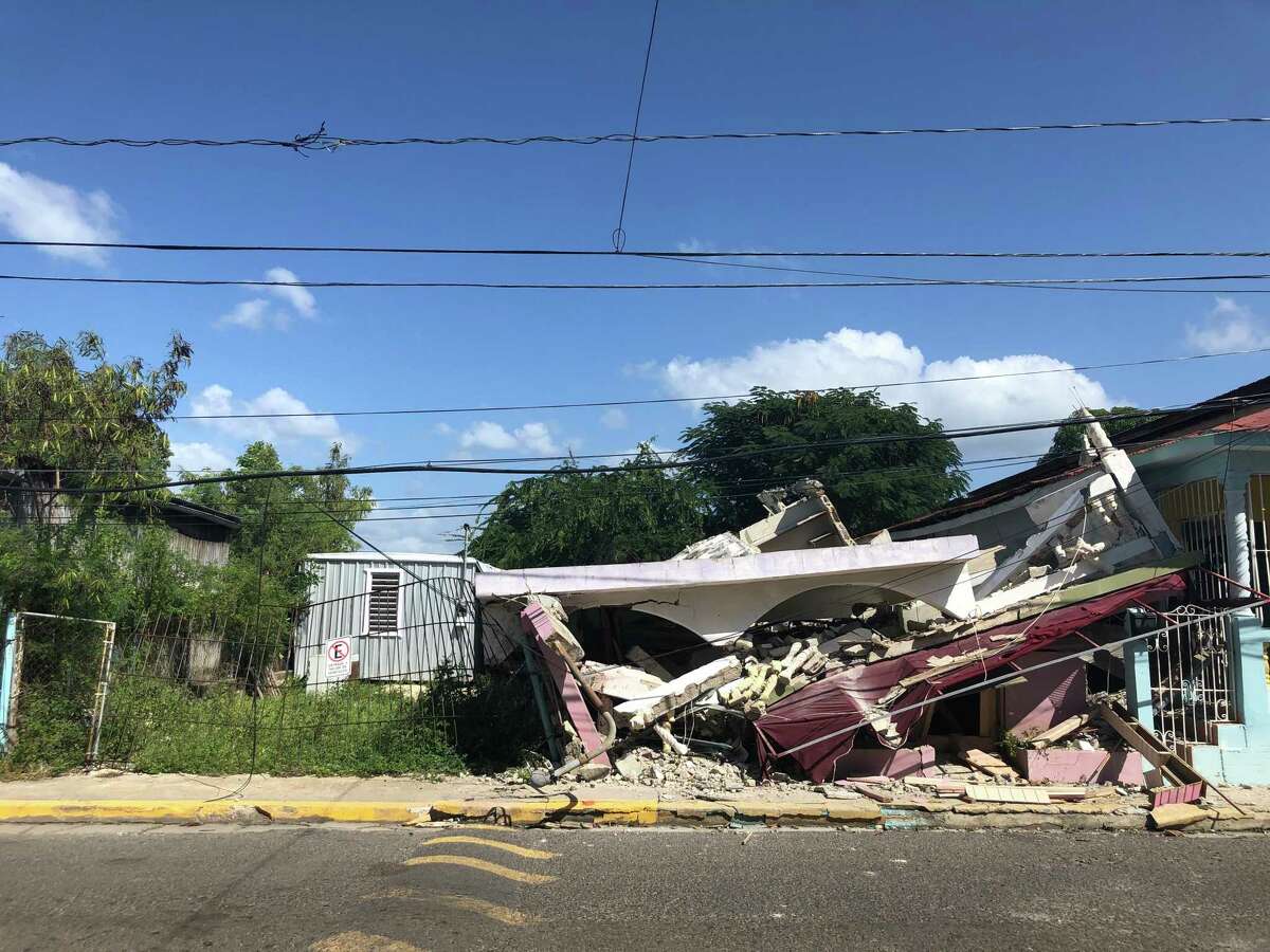 A house collapsed across the street from Angelica Hernández's home in Guánica, Puerto Rico. She fled with her family last week after powerful earthquakes cracked the ceiling. They are now living at a government-run camp for people displaced by the disaster.