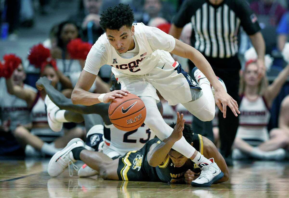 Connecticut’s James Bouknight, top, grabs a loose ball leaving Wichita State's Grant Sherfield, bottom, behind in the second half of an NCAA college basketball game, Sunday, Jan. 12, 2020, in Hartford, Conn.