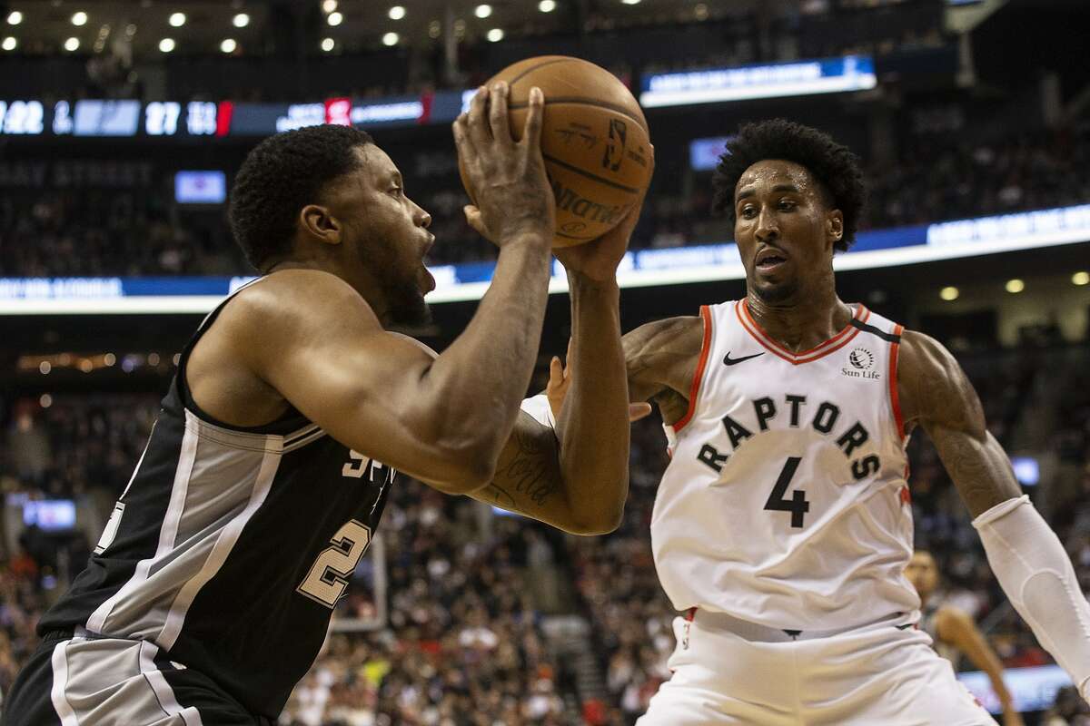 San Antonio Spurs' Rudy Gay, left, looks to make a play against Toronto Raptors' Rondae Hollis-Jefferson during first-half NBA basketball game action in Toronto, Sunday, Jan. 12, 2020. (Chris Young/The Canadian Press via AP)