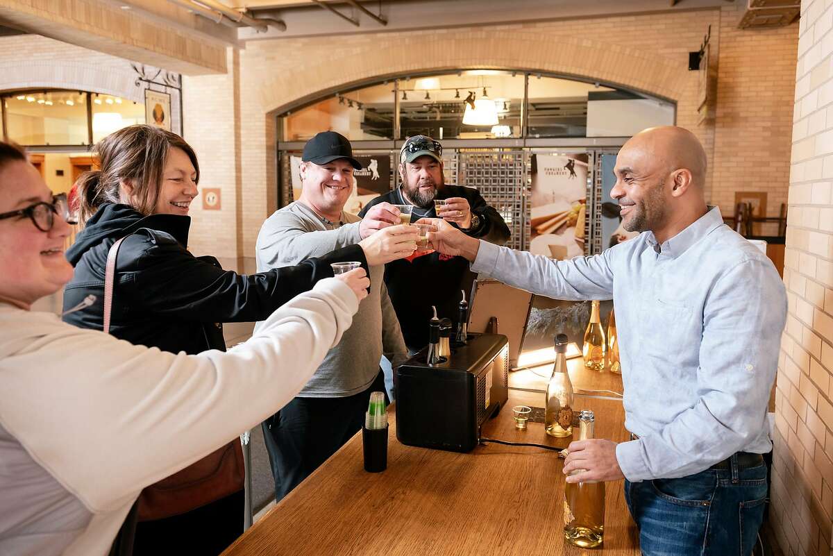 Owner Ayele Solomon, right, gives a cheers to guests Catherine Brown, left, Lori Liston, Bryan Brown, and Scott Liston during a tasting at Bee D'Vine Honey Wine Company's tasting bar in the Ferry Building in San Francisco, California, Thursday, January 9th, 2020.