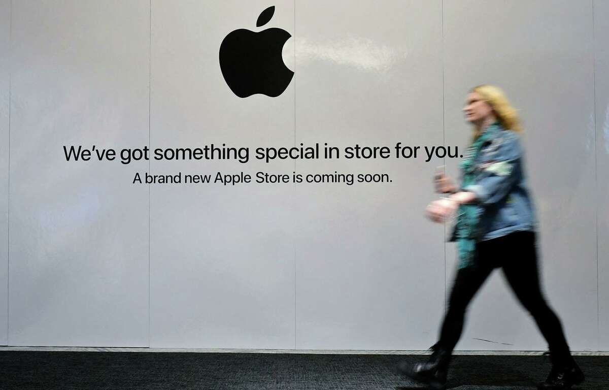 Shoppers walk past the sign heraldng the arrival of the Apple store in the new SoNo Collection mall Saturday, December 14, 2019, in Norwalk, Conn.