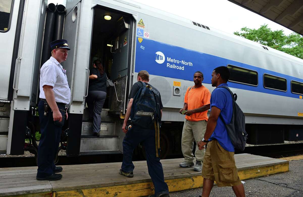 Commuters enter the Waterbury bound train at the Metro-North Derby train station in Derby, Conn. on Wednesday July 9, 2014.