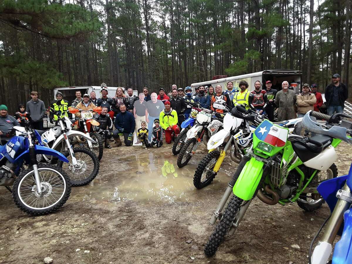 A large group of motorized dirt bike riders are pictured with cardboard cutouts of Mark Tracy and Larry Faulk. They passed away recently and the ashes of the two friends, Mark Tracy and Larry Faulk, were carried by their companions on the West Side Trail last year, and on the reopened East Trail this year.