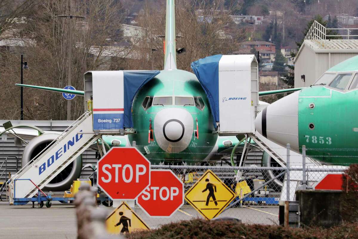 FILE - In this Monday, Dec. 16, 2019, file photo, Boeing 737 Max jets sit parked in Renton, Wash. American Airlines said Tuesday, Jan. 14, 2020, that it is removing the Boeing 737 Max from its schedule for two more months and canceling nearly 20,000 flights through early June, an acknowledgment of the ongoing uncertainty over when the grounded plane will fly again. (AP Photo/Elaine Thompson, File)