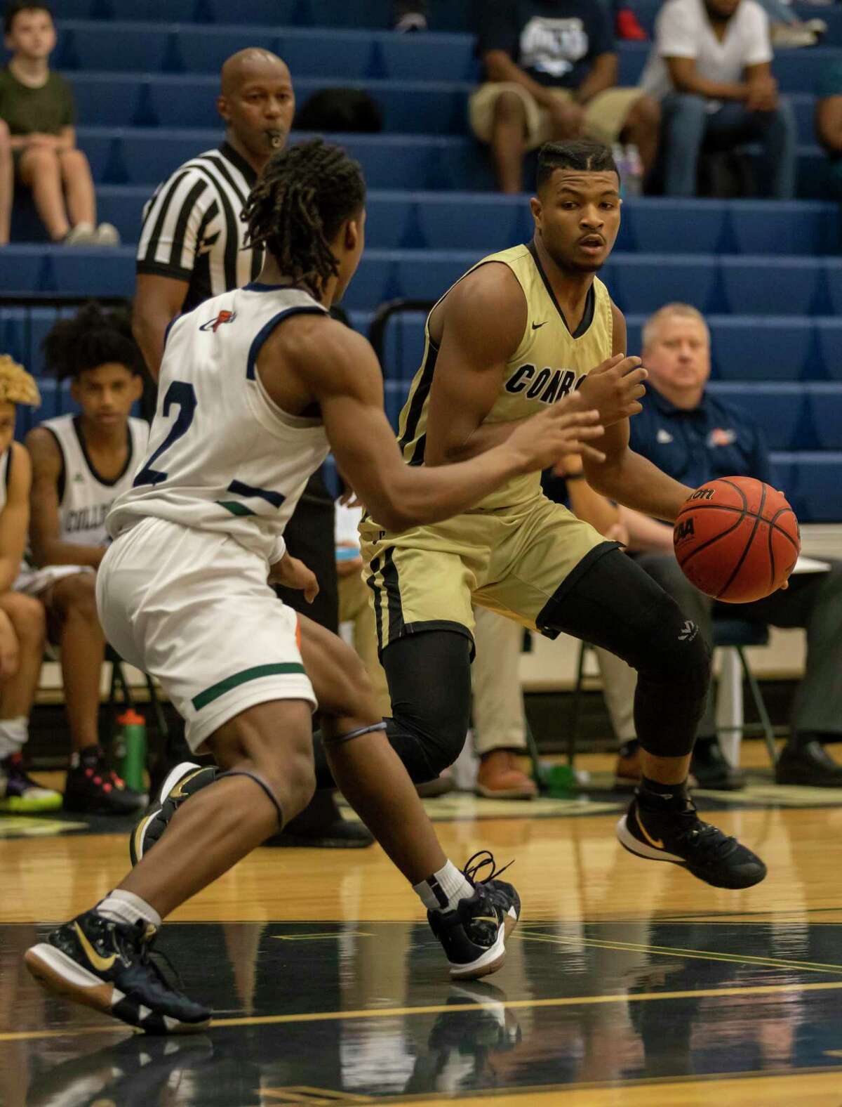 Conroe player Michael Phoenix (2) looks for an opening to pass the ball under pressure from College Park guard Marvin Dock (2) in a District 15-6A boys basketball game at College Park High School in The Woodlands.