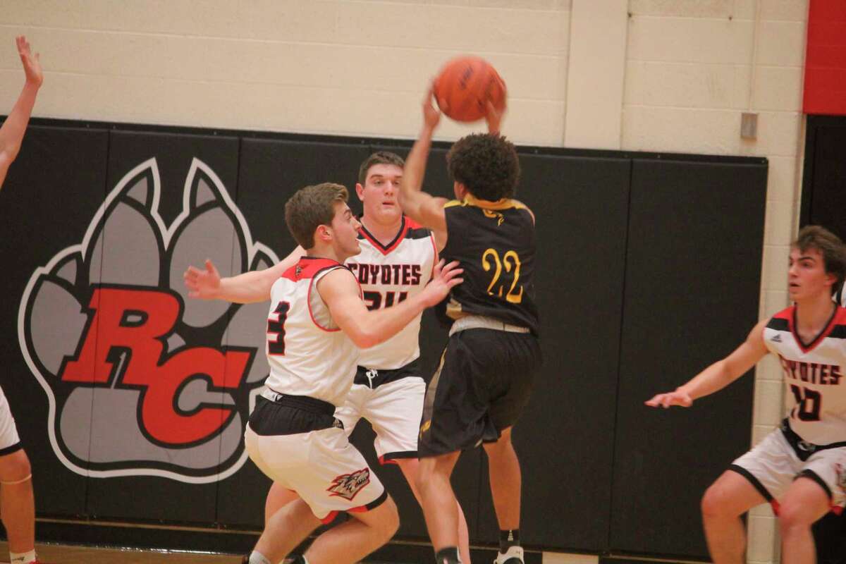 Reed City's Payton Hansen (left) and Canyon Reed (34) guard Reed City's Cameron Friend (22) on Friday. (Herald Review photo/John Raffel)