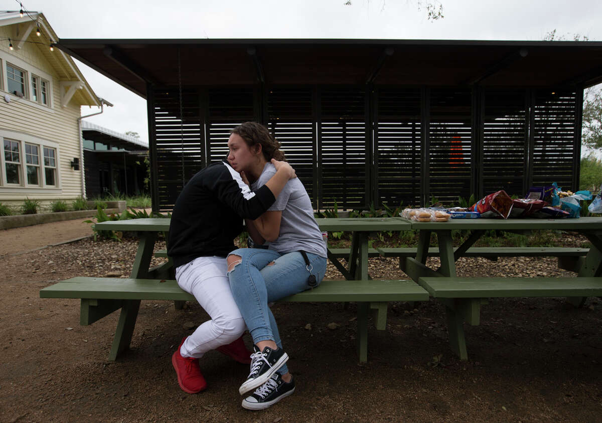 Bellaire High School students Emin Cruz, 16, and Grace Bandercan, 18, console each other at the gathering to remember the student who was shot and killed yesterday on campus at Evelyn Park on Wednesday, Jan. 15, 2020, in Bellaire.