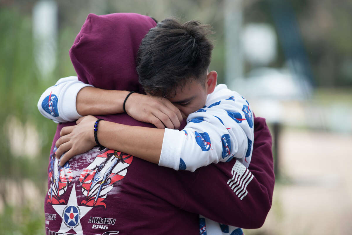 Bellaire High School students Viviana De La Torre, 17, and Adrian Interiano, 16, hug and console each other while gathering to remember the student who was shot and killed yesterday on campus at Evelyn Park on Wednesday, Jan. 15, 2020, in Bellaire.