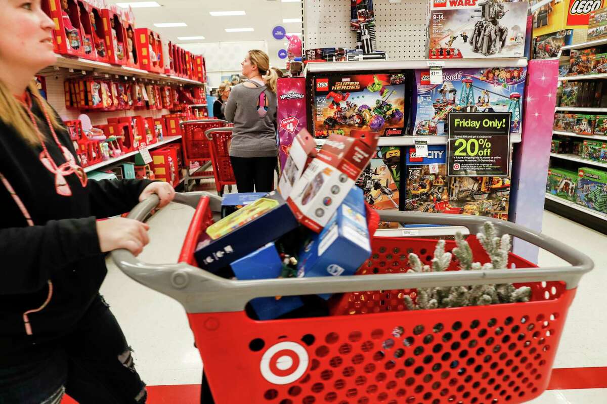 FILE- In this Nov. 23, 2018, file photo shoppers browse the aisles during a Black Friday sale at a Target store in Newport, Ky. Comparable stores sales at Target fell well below the previous year, joining a growing list of retailers reporting a meager performances during the critical holiday shopping season. Target said Wednesday, Jan. 15, 2020, that it had weaker-than-expected sales of electronics, toys and some home good. Those sales climbed 1.4% in the November-December period, compared with a 5.7% increase a year earlier. (AP Photo/John Minchillo, File)