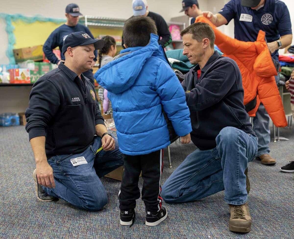 Gregory Nesom (right) and Tyler Becker of the Conroe Professional Firefighters Foundation, assisted in giving out coat during Operation Warm at Anderson Elementary in Conroe, Wednesday, Jan. 15, 2020. This was the second year that Anderson Elementary has held the drive.