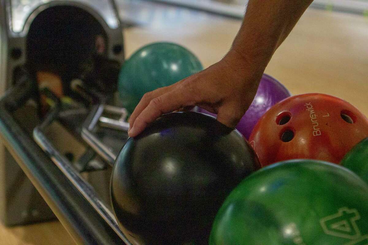 A bowler picks up his ball during the Racking Up Dollars for Scholars bowling tournament Saturday, July 20, 2019 at Time to Spare Entertainment in Cut and Shoot.