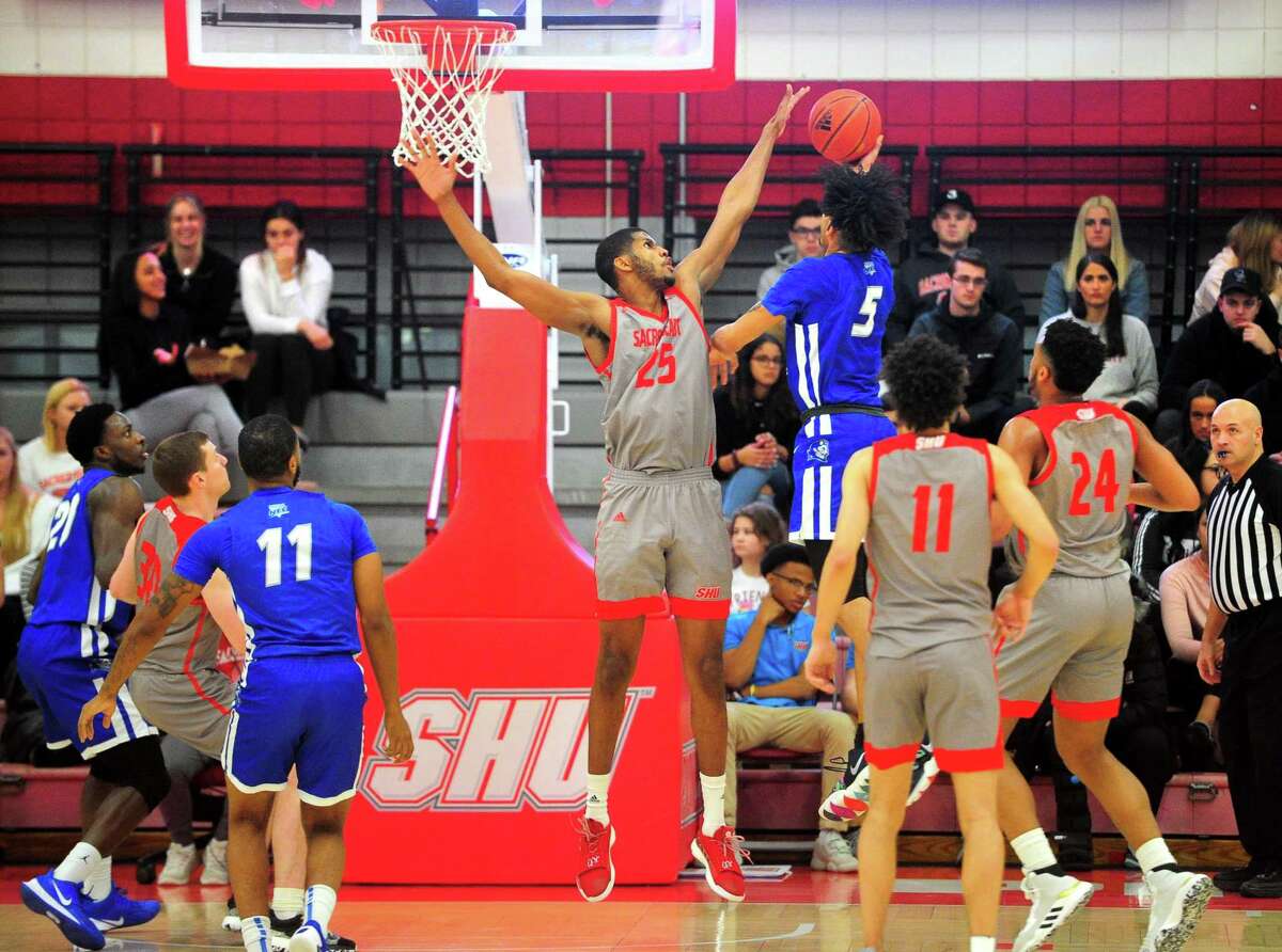 Sacred Heart's Jare'l Spellman (25) blocks a shot by Xavier Wilson (5) during mens college basketball in Fairfield, Conn., on Wednesday Jan. 15, 2020.